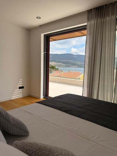 a bedroom with a large window with a large bed at Villa Karpa in Pridraga