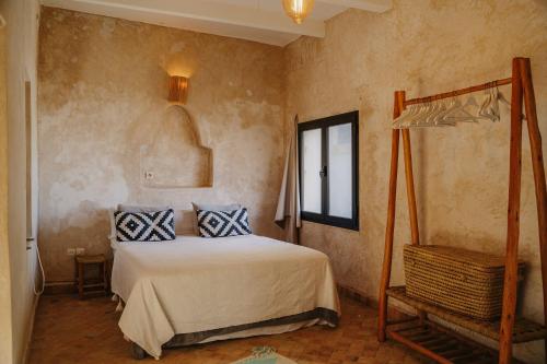a bedroom with a bed with blue and white pillows at Authentic Riad - Sea View & Rooftop Spa in Essaouira