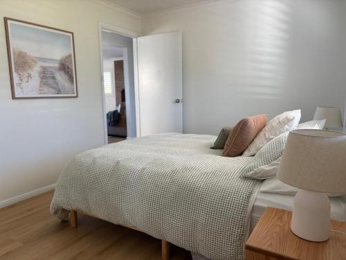 a bedroom with a bed and a table with a lamp at Five Little Ducks in Adventure Bay