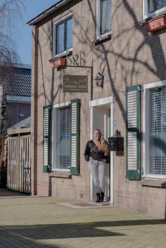 a woman standing in the doorway of a building at B&B Keukja Cuijk in Cuijk
