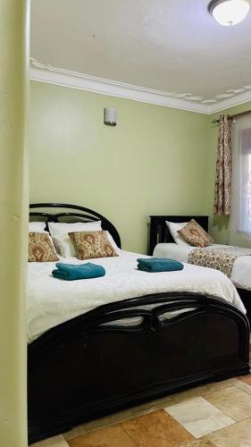 a bedroom with two beds with blue pillows on them at Blasto & Esita Cottages in Bunamwaya