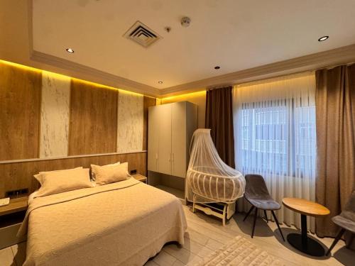 a bedroom with a bed and a chair and a window at Lavender Inn Hotel in Arnavutköy