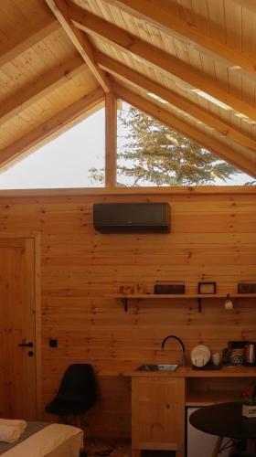 a kitchen in a wooden cabin with a window at Garden rooms in Kutaisi in Kutaisi