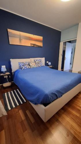 a bedroom with a large bed with blue sheets at Seaview Beach Front Grado Pineta Andromeda in Grado-Pineta