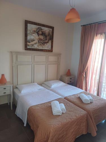 two beds in a bedroom with towels on them at Korali in Skiros