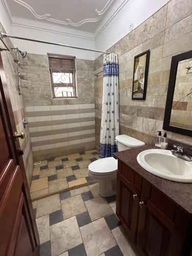 a bathroom with a toilet and a sink at Blasto & Esita Cottages in Bunamwaya