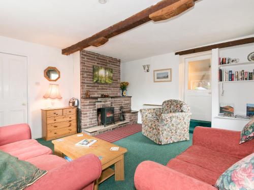 a living room with two couches and a fireplace at The Cottage in Gosforth
