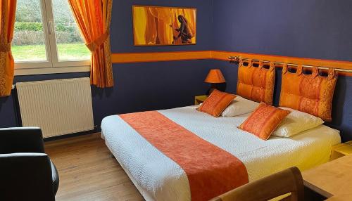 a bedroom with a bed with an orange and white blanket at La villa des palmiers in Soublecause