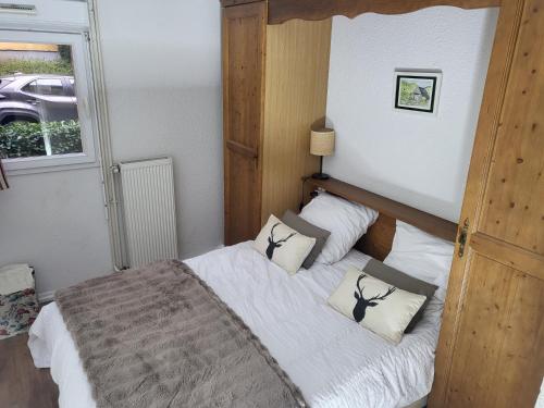 a bedroom with a bed with white sheets and pillows at Douce Altitudes Cauterets in Cauterets