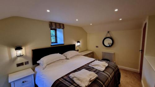 a bedroom with a bed with white sheets and pillows at Glandwr Cottage at Hendre Rhys Gethin in Betws-y-coed