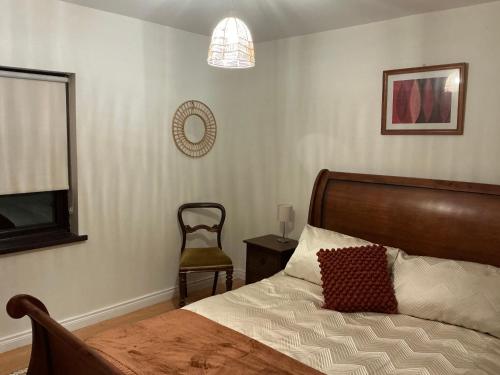 a bedroom with a bed and a chair and a lamp at Rose Cottage Moira in Moira