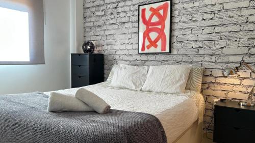 a bedroom with a bed and a brick wall at Apartamento La Calma in Lliber