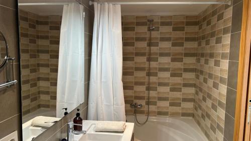 a bathroom with a tub and a sink and a shower at Apartamento La Calma in Lliber
