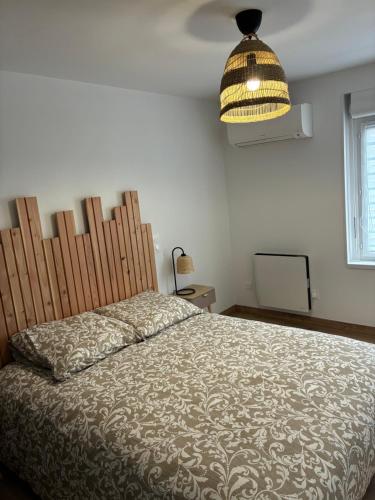 a bedroom with a bed and a light fixture at Cottage des Lacs in Puttelange-aux-Lacs