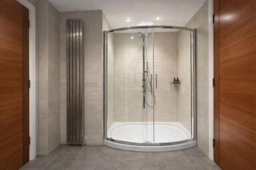 a shower with a glass door in a bathroom at Skyline Luxury Penthouse Belfast City Centre in Belfast