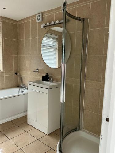 a bathroom with a shower and a sink and a mirror at Rose Cottage Moira in Moira