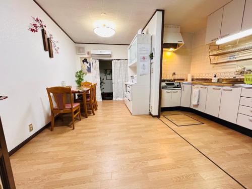 a kitchen with a table and a white refrigerator at 梅小路民宿 in Kyoto