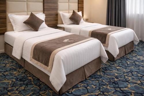 two beds in a hotel room with at منــازل الماسة للشقق المخدومة in Unayzah
