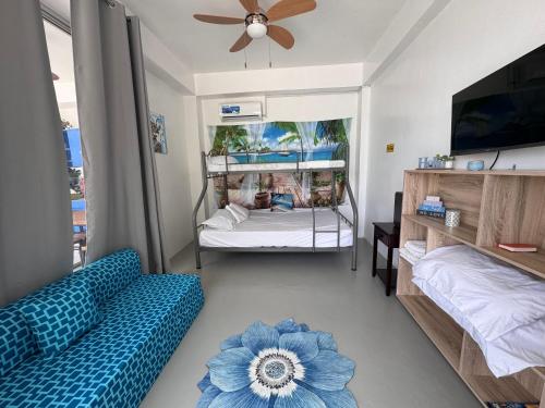 a living room with a blue couch and a bed at Taguilon Hidden Beach Cove Resort in Dapitan