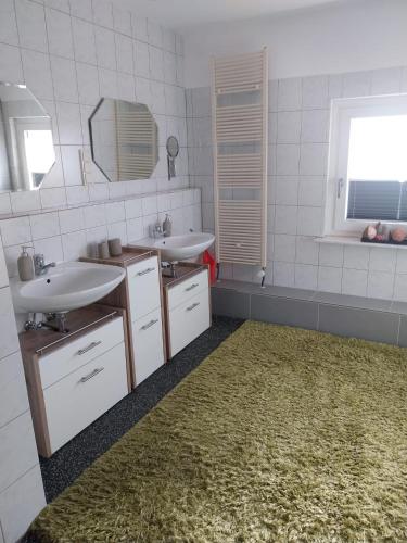 a bathroom with two sinks and a rug at Pension-Auszeit in Giesen