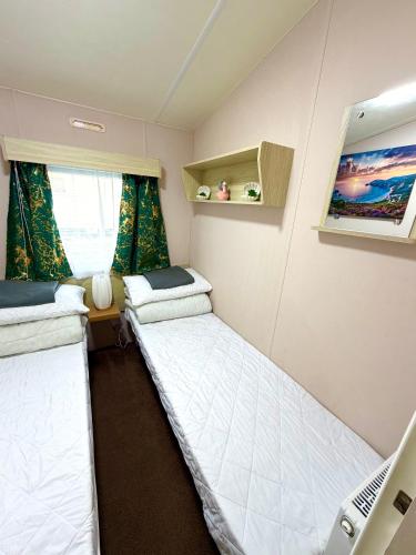 a small room with two beds and a laptop at Lyons Robin Hood Caravan in Rhyl-5 min walk to Beach ,FREE Wi-Fi and FREE parking for 4 cars, sleeps up to 8 people-3 bedrooms in Rhyl