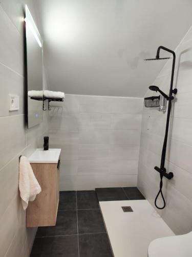 a white bathroom with a shower and a sink at Apartamento somo SARR in Somo