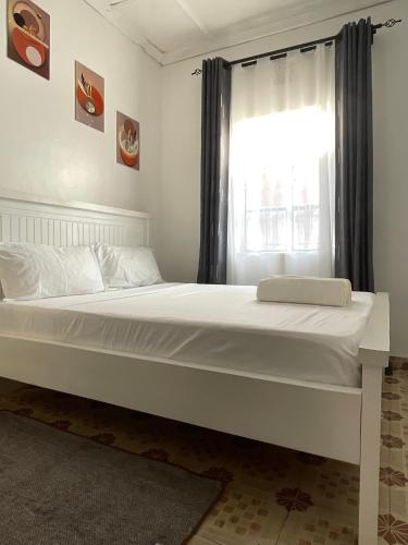 a large white bed in a room with a window at Jenka homes in Kitui