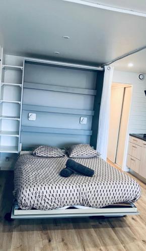 a bed with a blue headboard in a bedroom at Le Cocon étoilé in Métabief