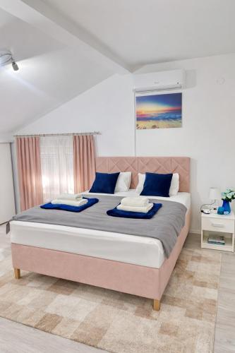 a bedroom with a large bed with blue pillows at Urban Gold Apartment in Mostar