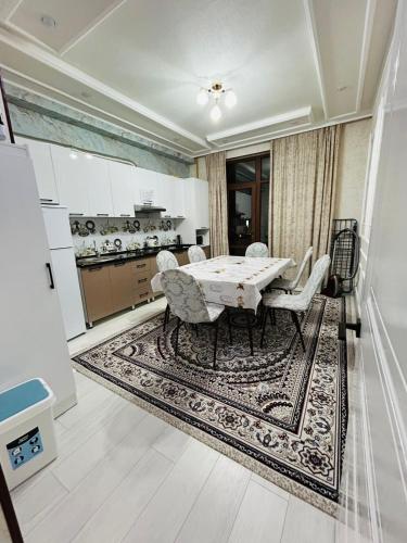 a dining room with a table and chairs on a rug at ЖК 2 Keruen Saray in Türkistan