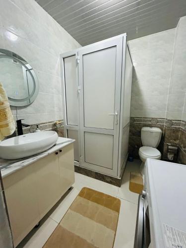 a bathroom with a toilet and a sink and a mirror at ЖК 2 Keruen Saray in Türkistan