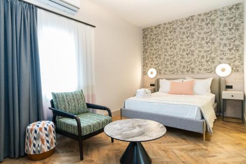 a bedroom with a bed and a chair and a table at Casa Alloro Bodrum in Bodrum City