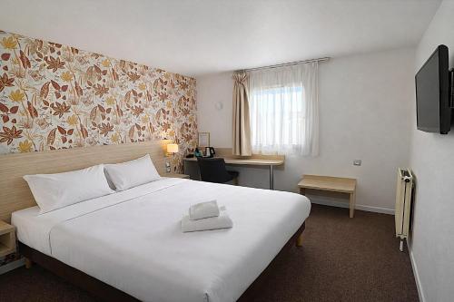 ein Hotelzimmer mit einem großen weißen Bett und einem Fenster in der Unterkunft Logis Hotel Altina in Pacy-sur-Eure