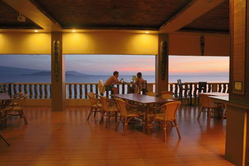 two people sitting at a table on a balcony with a view at Turtle Bay Dive Resort in Moalboal