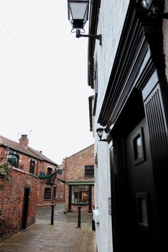an alley in an old brick building with a black door at Britannia Lodge in Howden