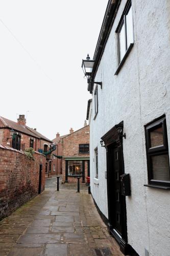 an alley with a white building with a door at Britannia Lodge in Howden