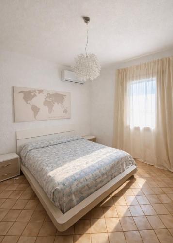 a bedroom with a bed and a window and a chandelier at Casa Franco in Lampedusa