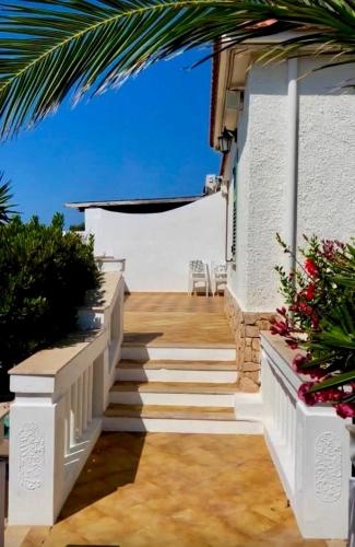 a stairway leading up to a white building with flowers at Casa Franco in Lampedusa