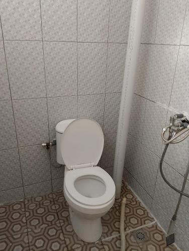 a bathroom with a white toilet in a stall at Cemara Paradise Homestay in Pulau Gilimelayu