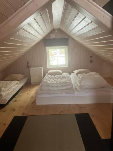 a bedroom with two beds and a window at Stuga vid viltåker nära norska gränsen in Strömstad