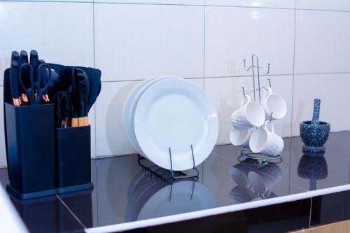 a counter with a white plate and utensils on it at Eunia homes in Kibarani