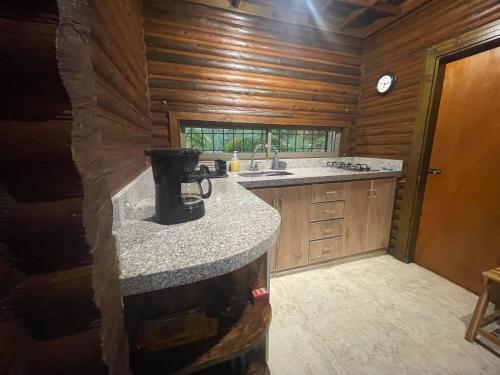 a kitchen with a counter top in a log cabin at Chalet Palo DAgua in Turbaco