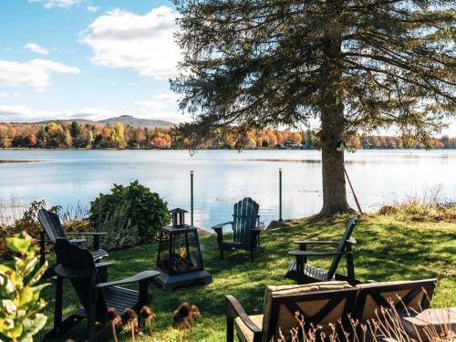 a group of chairs sitting next to a lake at Le Selby in Dunham