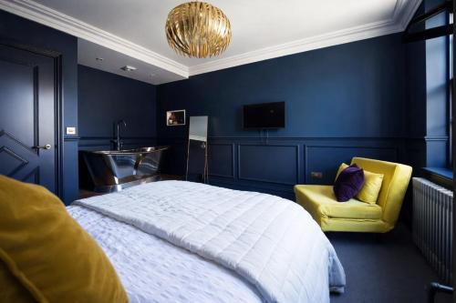 a bedroom with a bed and a yellow chair at 4 Bedroom House for Work Crews, Each Guest Has Own Room, Weekly Rates by Bluehouse Shortlets Brighton in Brighton & Hove