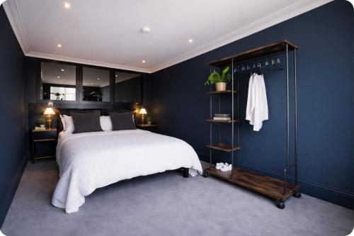 a bedroom with a bed and a blue wall at 4 Bedroom House for Work Crews, Each Guest Has Own Room, Weekly Rates by Bluehouse Shortlets Brighton in Brighton & Hove