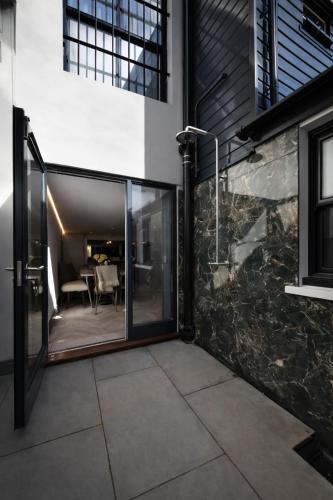 a glass door leading to a patio with a table at 4 Bedroom House for Work Crews, Each Guest Has Own Room, Weekly Rates by Bluehouse Shortlets Brighton in Brighton & Hove