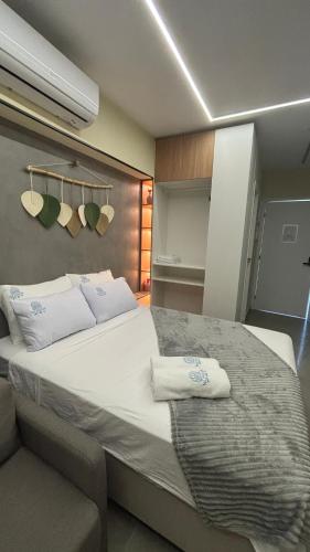 a bedroom with a large bed with towels on it at Beira mar Flat Deluxe Nomar Carneiros Ecoliving Réveillon in Tamandaré