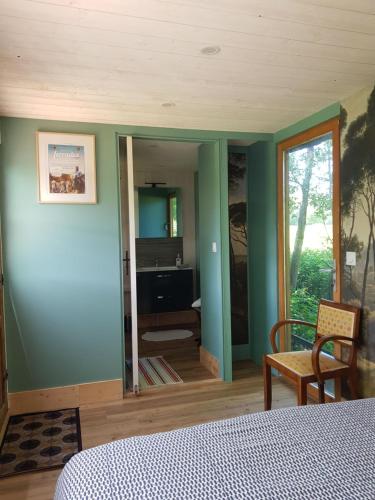 a bedroom with green walls and a bed and a mirror at Le Riolet in Marsac-en-Livradois