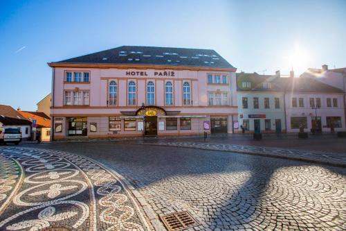 a building on a cobblestone street in a town at Hotel Paříž in Jičín