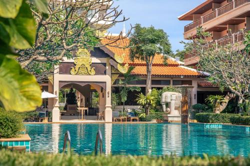 a swimming pool in front of a building at Avalon Beach Resort Pattaya in Pattaya South